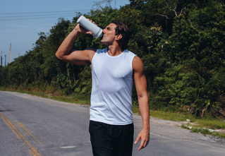 man drinking water on the road